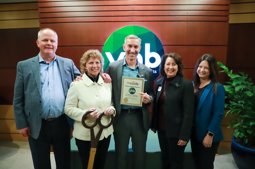 YHB and community leaders pose for a photos at the 2025 ribbon cutting event for YHB's new corporate headquarters.
